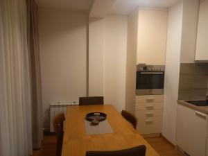 a kitchen with a wooden table with chairs and an oven at Vila Borova Zlatibor Apartman 501 in Zlatibor