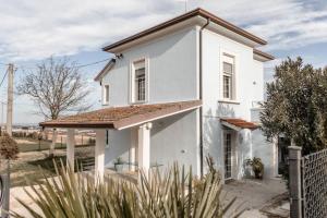 een wit huis met een bruin dak bij Villa panoramica vista mare in Gradara