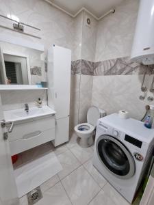 een witte badkamer met een wasmachine bij Silver city 1 in Jagodina