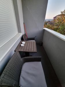 een klein balkon met een houten tafel en een raam bij Silver city 1 in Jagodina