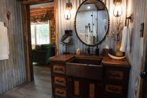 a bathroom with a sink and a mirror at Hobbit Treehouse with waterfall on the Brazos River! 350 acres! Tubing! Petting zoo! in Weatherford