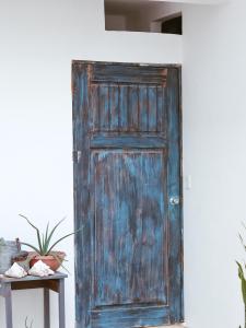 an old wooden door in a room with a table at Kay Apartments Isla Mujeres in Isla Mujeres