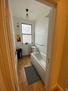 a bathroom with a bath tub and a window at Gorgeous Two Bedroom Apartment in London
