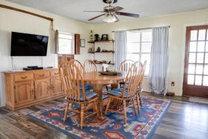 uma sala de jantar com uma mesa de madeira e cadeiras em Stay on a 350-acre Cattle Ranch! Brazos River! Tubing! Petting zoo! em Weatherford