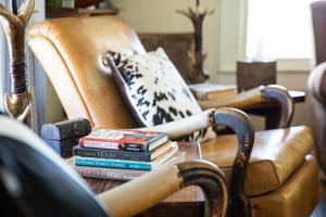 una pila de libros sentados en una mesa con una silla en Stay on a 350-acre Cattle Ranch! Brazos River! Tubing! Petting zoo!, en Weatherford