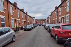 a row of cars parked on the side of a street at Tallis House, Sleeps 5, near City Centre, Free Parking, Long or Short Stays - by NMB Property in Manchester
