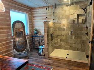 a bathroom with a tub and a mirror at "Magical Treehouse" w spiral slide off the deck 350 acres on the Brazos River! Tubing! Petting Zoo! in Weatherford