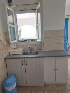 a kitchen with a sink and a window at CIELO Summer House Paros in Santa Marina