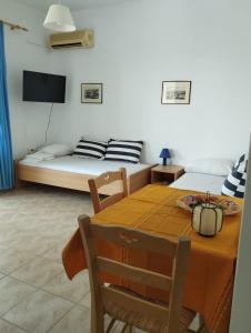 ein Esszimmer mit einem Tisch und einem Bett in der Unterkunft CIELO Summer House Paros in Santa Marina