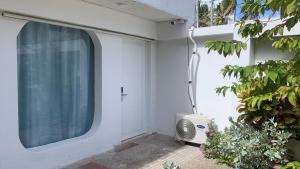 a window on the side of a white house at Apartamentos CC San Andres cerca a la playa in San Andrés +25 photos