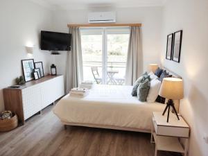 a bedroom with a large bed and a window at The Surf Studio - Ericeira in Ericeira