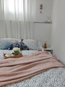 een bed met een deken en een kom bloemen erop bij Apartment46 in Mali Lošinj