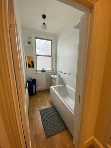 a bathroom with a tub and a toilet and a window at Gorgeous Two Bedroom Apartment in London