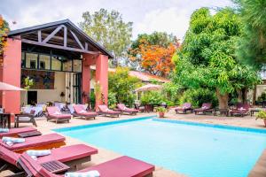 einen Pool in einem Hotel mit Liegestühlen und einem Resort in der Unterkunft Hibiscus House Gambia in Brufut