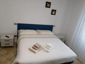 a bedroom with a white bed with towels on it at MAWA in Ferrara