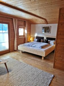 ein Schlafzimmer mit einem großen Bett in einem Holzzimmer in der Unterkunft Ferienhaus Innerkienzerhof - Urlaub am Bauernhof in Matrei in Osttirol