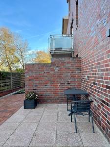 a black bench sitting next to a brick wall at Hotel Ocean in Norden