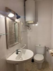 a white bathroom with a toilet and a sink at El Racó de Xivert in Alcalá de Chivert