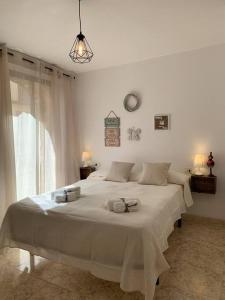 a white bedroom with a large white bed with towels on it at El Racó de Xivert in Alcalá de Chivert