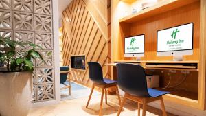 an office with two chairs and a desk with a computer at Holiday Inn Auckland Airport by IHG in Auckland