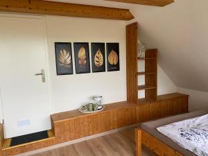 sypialnia z łóżkiem i zdjęciami na ścianie w obiekcie Huck’s Ferienhäuser w mieście Borstel
