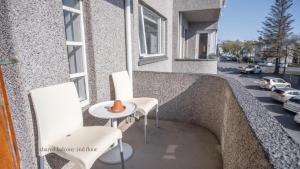 two white chairs and a table on a balcony at Apartments Reykjavik in Reykjavík