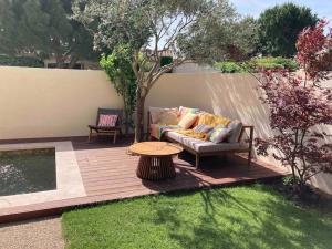 une terrasse en bois avec un canapé et une table dans l'établissement Maison familiale chaleureuse narbonne, à Narbonne