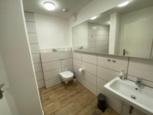 un bagno con un water, un lavandino e uno specchio di Huck’s Ferienhäuser a Borstel Altre 86 foto