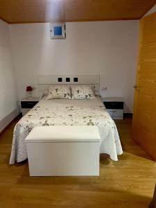 1 dormitorio con cama blanca y mesa blanca en A Casa do Abuelo, en Ourense