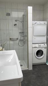 a bathroom with a shower and a washing machine at SEASIDE Appartement in Staad