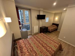 a hotel room with two beds and a window at Hipotel Paris Printania Maraichers in Paris