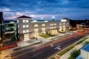 a building on the side of a street with a road at Hotel Madison & Shenandoah Conference Ctr. in Harrisonburg