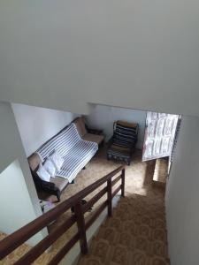 an attic room with a bed and a chair at Casa no centro de Bananeiras PB in Bananeiras