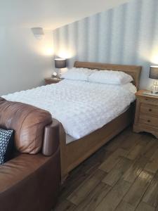 1 dormitorio con 1 cama grande y 1 sofá en Garden Suite en Rhuddlan