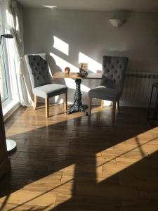 een woonkamer met 2 stoelen, een tafel en een raam bij Garden Suite in Rhuddlan