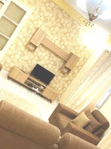 a living room with a couch and a tv at 2 chambres-salon-cuisine-balcons sup 80m2 in Dakar