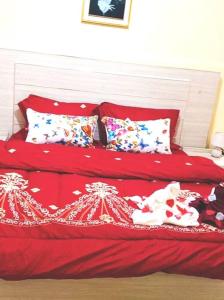a red bed with red sheets and pillows at 2 chambres-salon-cuisine-balcons sup 80m2 in Dakar