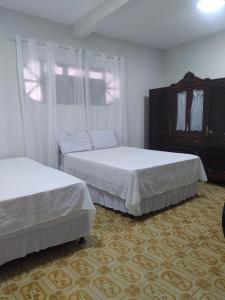 a bedroom with two beds and a dresser at Casa no centro de Bananeiras PB in Bananeiras