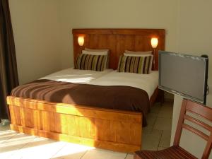 a bedroom with a bed and a tv at Pension Kamperland in Kamperland
