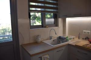 a kitchen with a sink and a window at Seashell ap NEAR THE BEACH in Artemida