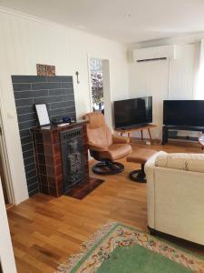 a living room with a fireplace and a tv at Sjarmerende feriehus i Olden rett ved fjorden in Stryn