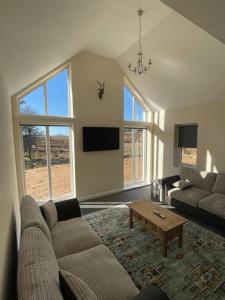 a living room with a couch and a table at Remote Wilderness - sleeps 4 to 6 in Halkirk