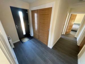 an empty hallway with a wooden door in a house at Remote Wilderness - sleeps 4 to 6 in Halkirk