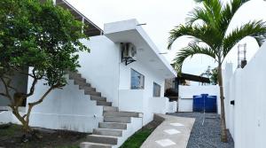 Biały dom ze schodami i palmą w obiekcie Kánela Hotel - Cabañas w mieście Pedernales