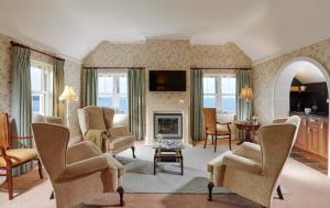 - un salon avec des chaises et une cheminée dans l'établissement Red Cliff Lodge, à Spanish Point