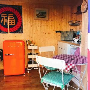 a kitchen with a red refrigerator and a table and chairs at Cosy Private Cabin with parking in good location in Oxford