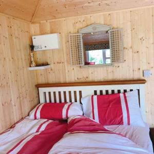 a room with a bed with two pillows on it at Cosy Private Cabin with parking in good location in Oxford