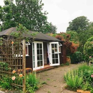 a small brown and white house in a garden at Cosy Private Cabin with parking in good location in Oxford