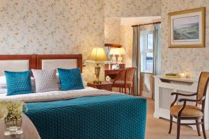 Un dormitorio con una cama y una mesa y sillas. en Red Cliff Lodge, en Spanish Point 17 fotos más