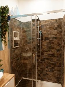 um chuveiro na casa de banho com uma parede de tijolos em Luxury Beach House em Torvaianica